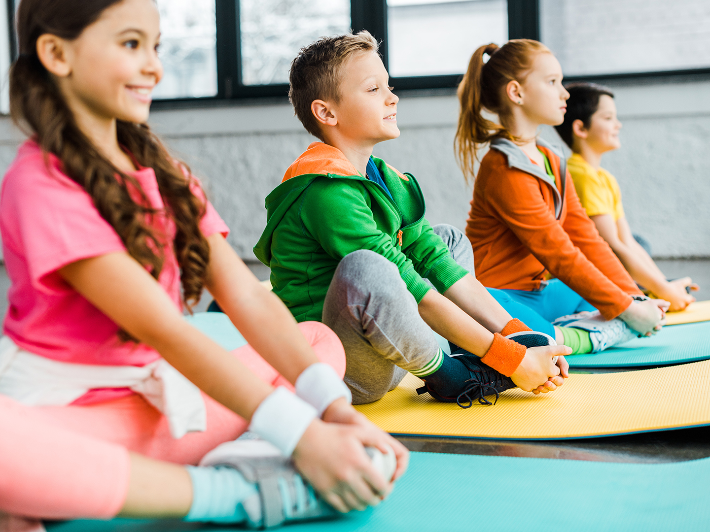 Kinder dehnen sich auf Gymnastikmatten