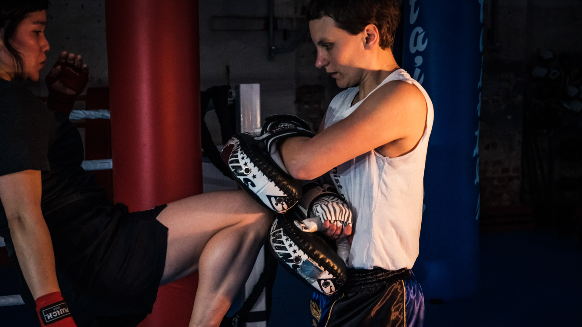 Zwei Personen beim Kickboxtraining, eine hält Pratzen, die andere führt einen Kick aus, im Rahmen des Vereinswettbewerbs '(M)ein Verein gegen Rassismus' von Sidekick Leipzig