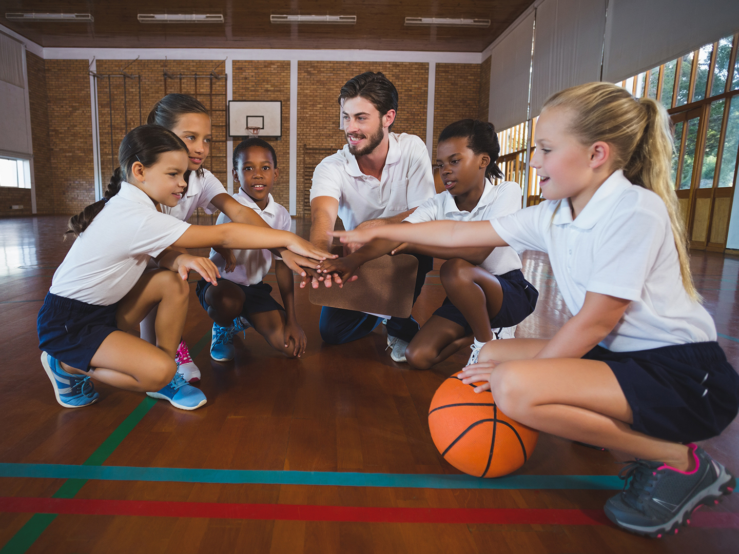 ein Trainer schwört sein Team aus Jugendlichen auf Basketball-Spiel ein.