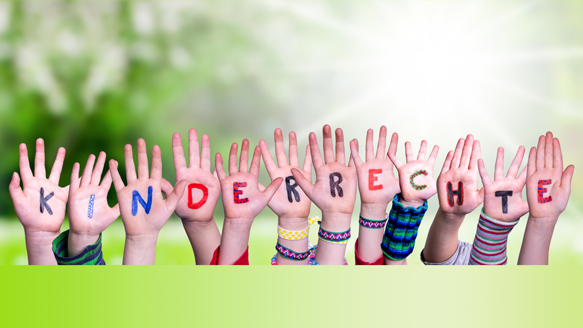 Mehrere Kinder strecken ihre bunt bemalten Hände in die Höhe, auf deren Handflächen das Wort „KINDERRECHTE“ in farbigen Buchstaben geschrieben steht. Die Hände bilden eine fröhliche Reihe vor einem hellen, naturhaften Hintergrund. Das Motiv symbolisiert sichtbar die Bedeutung von Kinderrechten in Deutschland und passt zur Veröffentlichung des Kinderrechte‑Index 2025 des Deutschen Kinderhilfswerks.