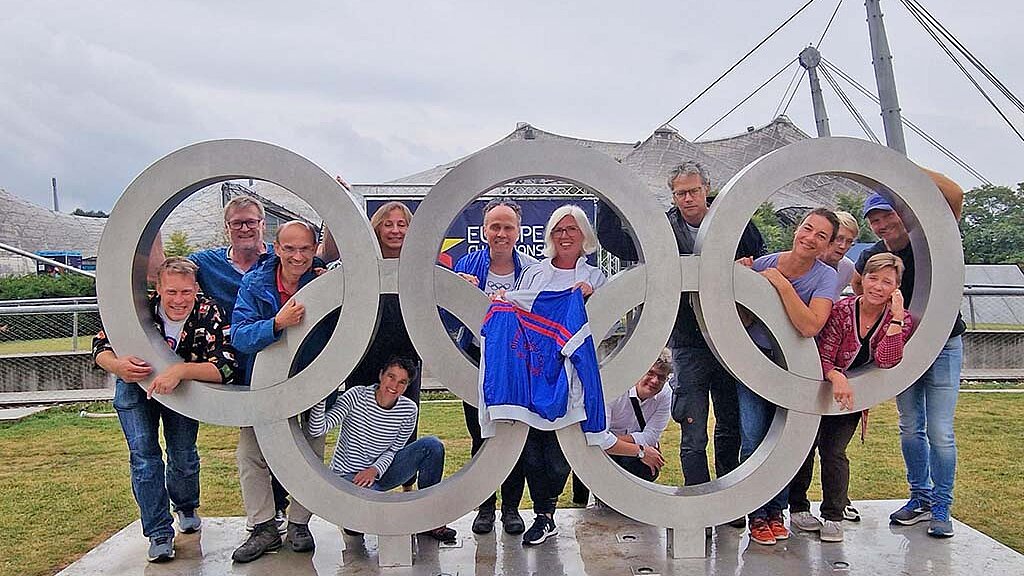 Gruppenfoto mit olympischen Ringen vor dem Olympiastadion München