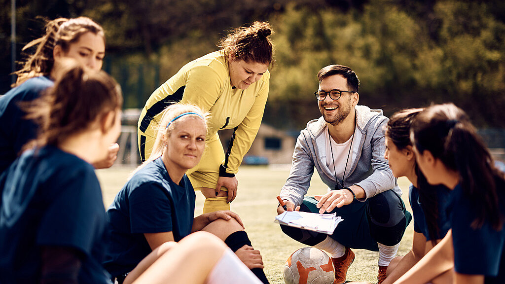 Ein Trainer erklärt seinem Frauenfußballteam die Taktik