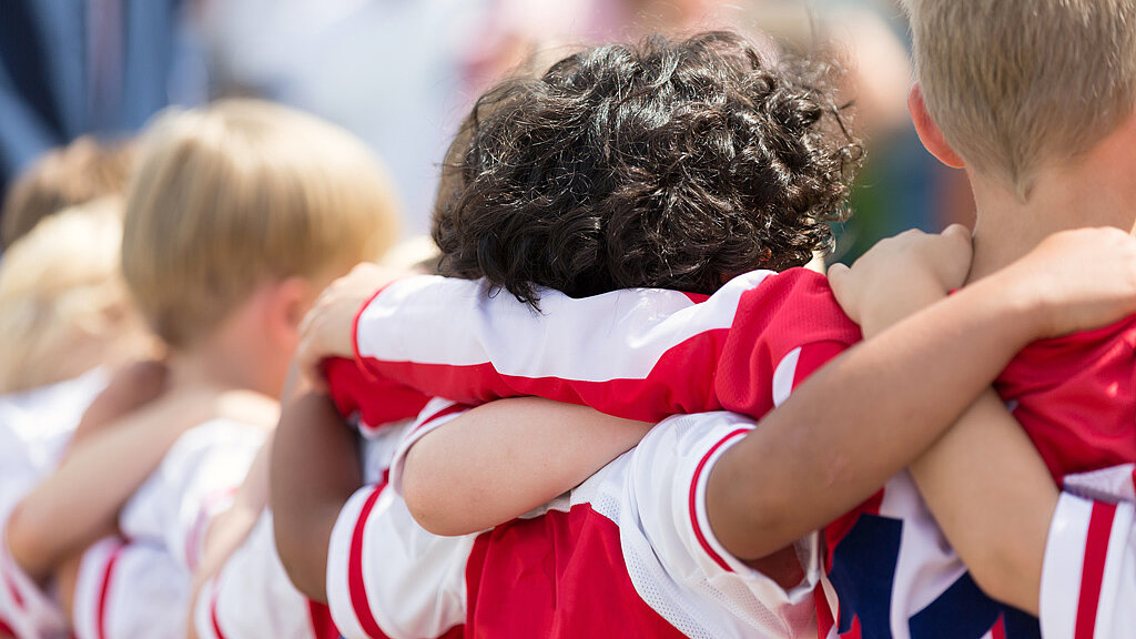 Fußballspieler stehen Arm in Arm zusammen