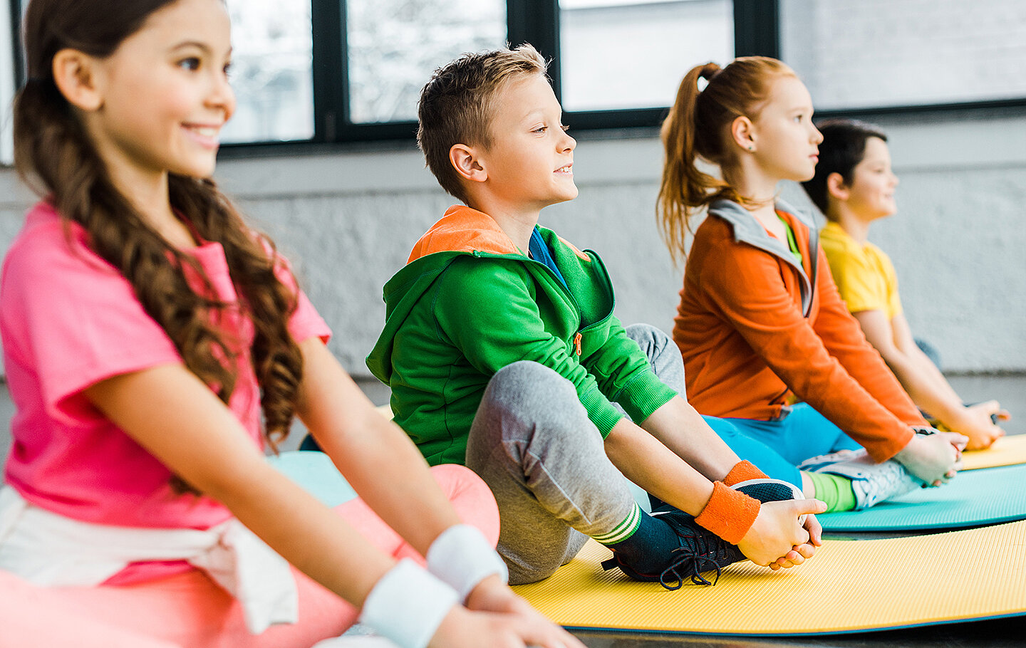 Kinder dehnen sich auf Gymnastikmatten