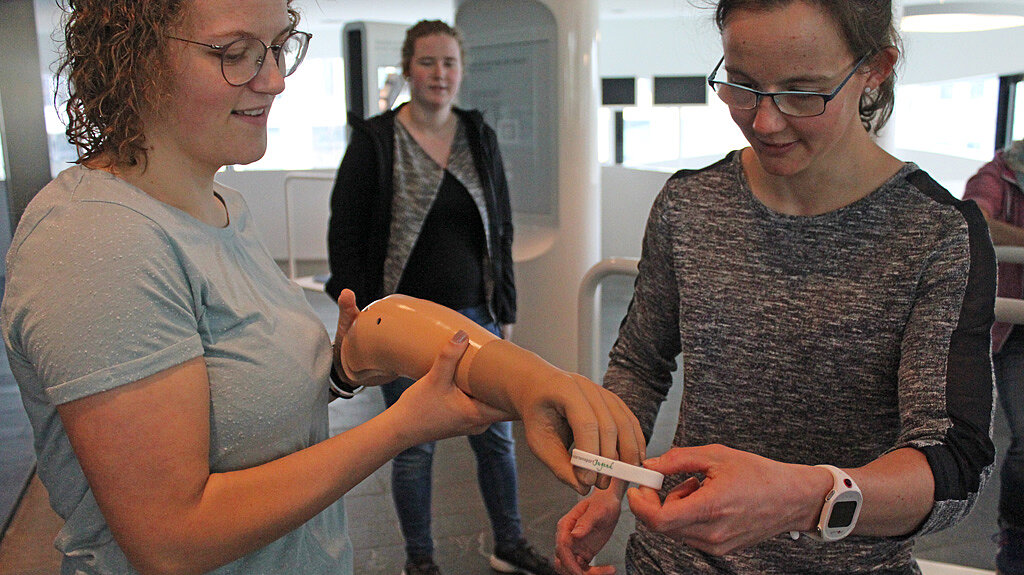 Juniorbotschafterinnen beim Testen der Bedienung einer Armprothese