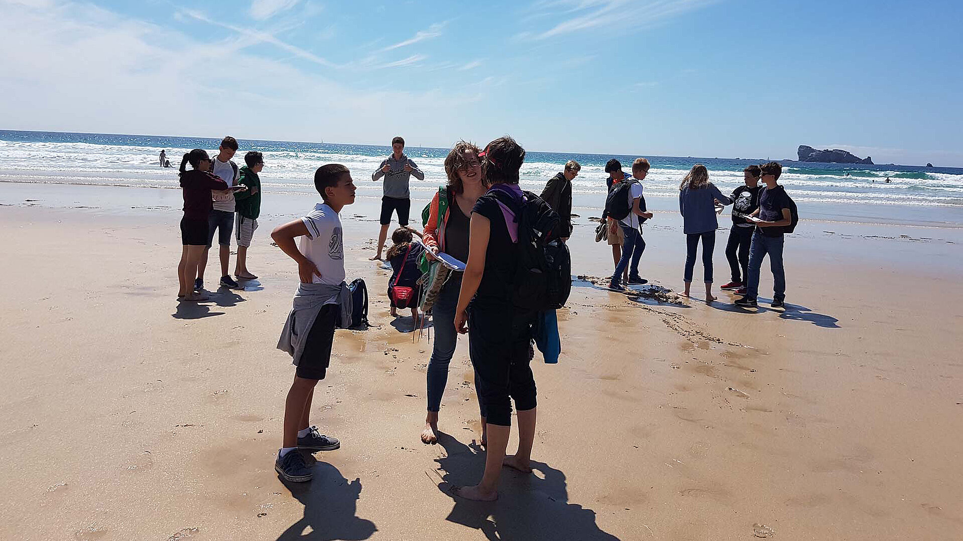 Eine Gruppe Jugendlicher steht am Strand von Saint Malo