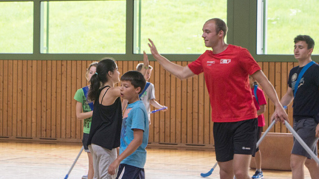 Sebastian Schoenle klatscht Jugendliche in der Halle ab.