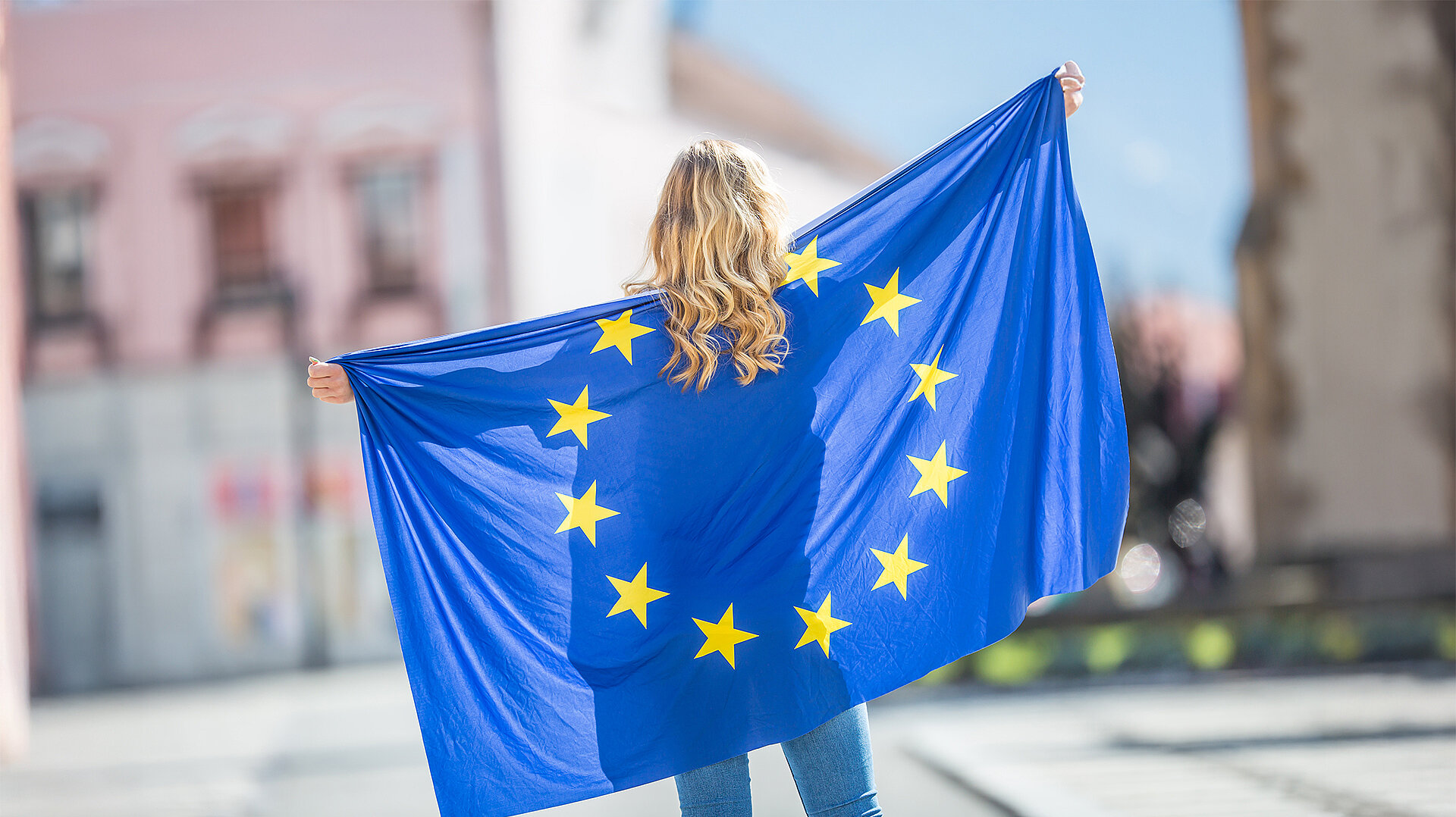 Jugendliche mit europäischer Flagge, die an Sportworkshops in Europa teilnehmen.
