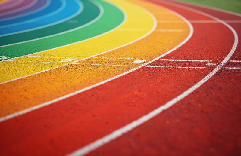Laufbahn mit farbigen Bahnen in Regenbogenfarben von Rot bis Blau