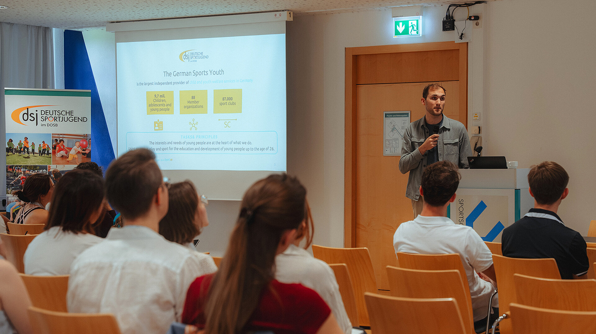 Vorstandsmitglied Luca Wernert hält Vortrag bei EUYOUSPORT-Workshop vor Publikum in Seminarraum.